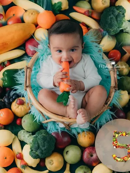 A beautiful overhead shot of the entire fruit and veggie setup, celebrating this baby's 5-month milestone and the spirit of Holi.