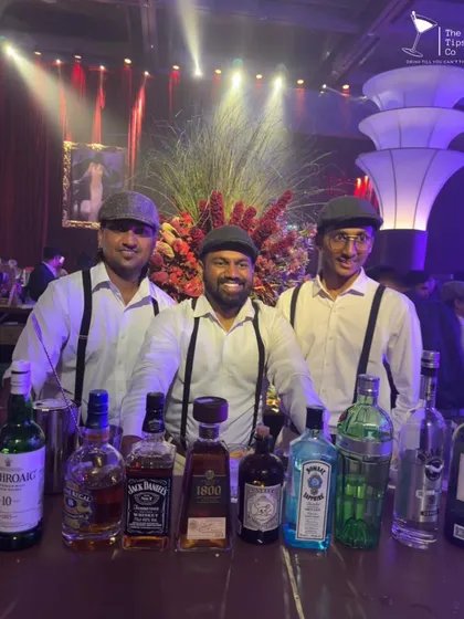 Our team dressed in Peaky Blinders-style outfits for a themed event. We are ready to serve from a bar stocked with premium brands like Jack Daniel's and Bombay Sapphire.
