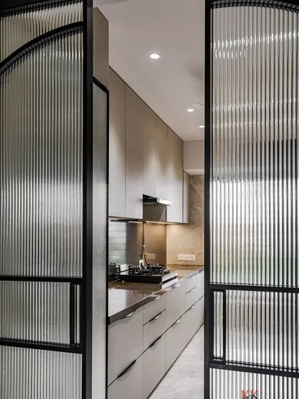 The entrance to our parallel modular kitchen in Kandivali, featuring elegant fluted glass doors that add texture and privacy.
