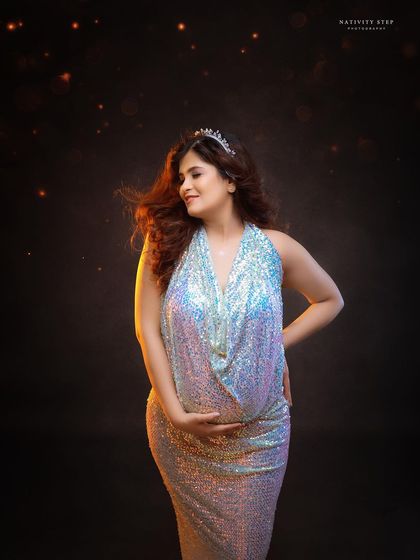 A glamorous solo portrait in a shimmering sequined gown. The warm lighting and flying sparkles add a touch of magic and celebration.