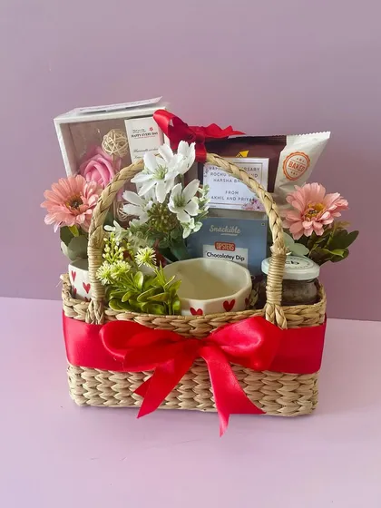 A Kauna basket hamper perfect for Valentine's Day or an anniversary. It's filled with heart-themed mugs, chocolates, and other romantic treats.