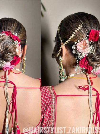 This bridal bun combines a sleek finish with a textured, woven bun, adorned with a mix of pink and red roses. It's a beautiful choice that complements a traditional red lehenga perfectly.