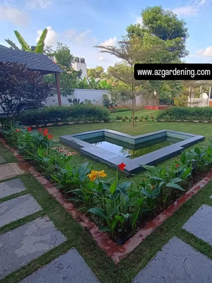 This heart-shaped pond is a unique custom feature in this garden, bordered by canna lilies. It adds a personal and charming touch to the landscape.