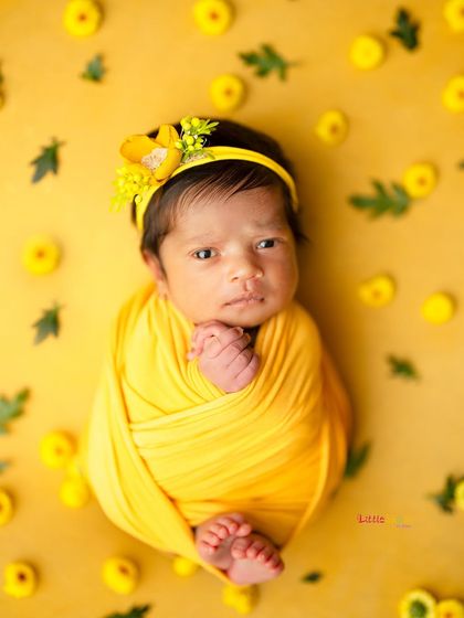 This little one is wide-eyed and curious in this bright yellow setup. Capturing these alert moments is just as special as the sleepy ones.