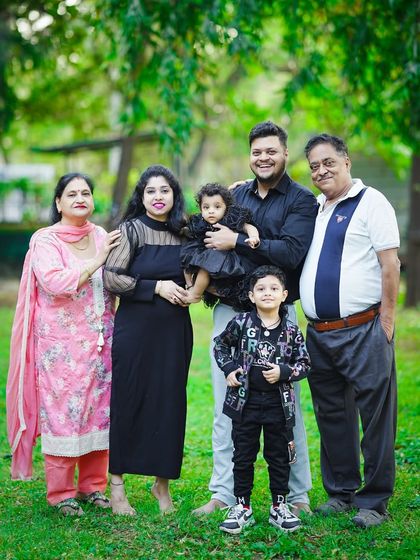 A wonderful multi-generational family portrait taken outdoors, with grandparents, parents, and children all together in one frame.