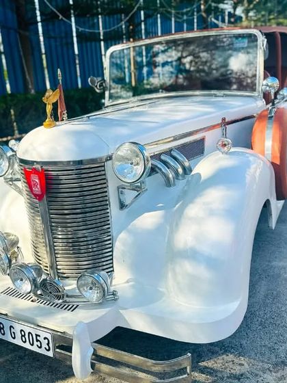 A front view of the vintage car, highlighting its grand grille and classic design details. It’s a surefire way to make a memorable and elegant entrance on your wedding day.