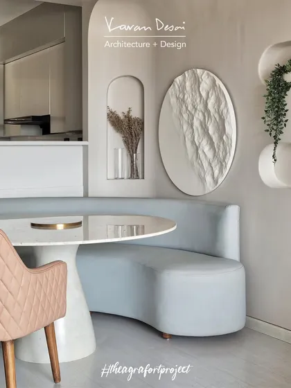 The dining area in the Agra Fort Project features a custom marble table and a curved, built-in banquette. The design creates an intimate and cozy spot for family meals.