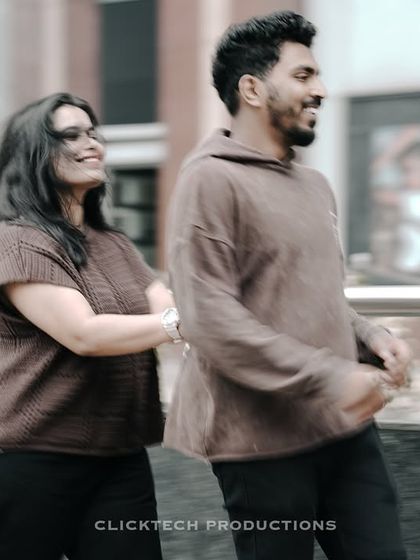 A motion-blur shot of a couple walking and laughing, conveying a sense of fun and energy during their urban shoot.
