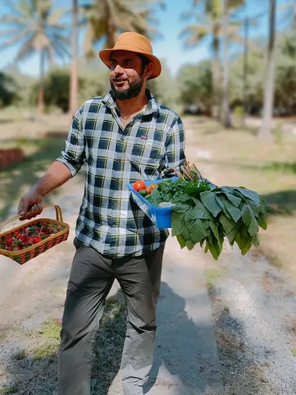 From our farm to your fork, this is the goal. Our farm manager is carrying a fresh harvest of strawberries, tomatoes, and leafy greens, all grown using our sustainable hydroponic methods.