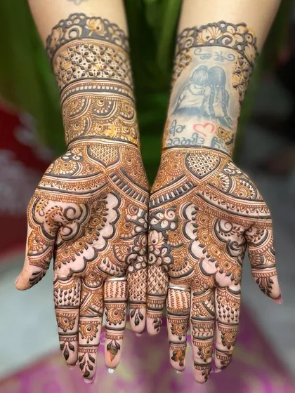 This bride wanted to incorporate her existing tattoo into the mehendi. I designed the henna to flow around the portrait tattoo, making it a unique and integrated part of her bridal look.
