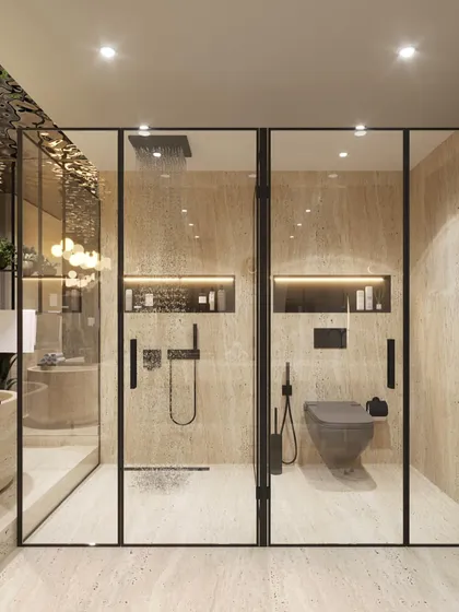 A view of the glass-enclosed shower and toilet area in the travertine spa bathroom. The black framing adds a modern, graphic contrast to the warm stone, showcasing our attention to detail in creating functional, separated zones.