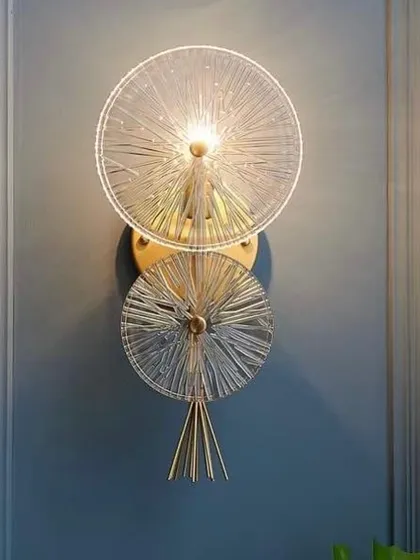 A wall sconce made of two fluted glass discs. This fixture creates a beautiful sunburst effect, adding a touch of art deco style.