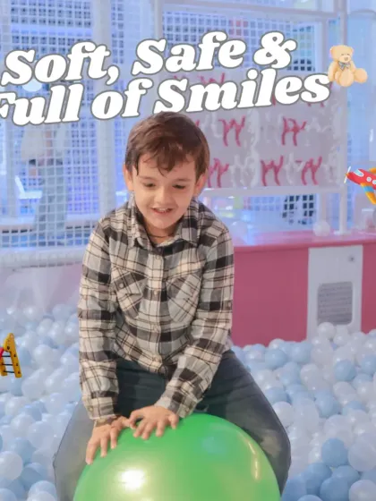 Soft, safe, and full of smiles. Here, a young boy enjoys bouncing on a large green hopper ball in our massive, cushioned ball pit.