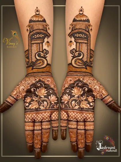 A designer mehndi featuring graceful swans beneath a jharokha on the arms, with blooming lotuses on the palms. This is a beautiful blend of architectural and natural elements.