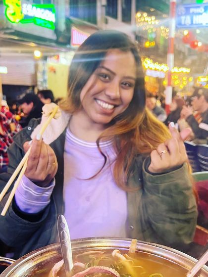 A happy moment from my December travels, enjoying a hot pot meal on a bustling street, giving a glimpse into my love for food and travel.