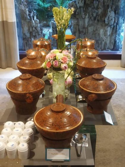 The same Asian buffet setup with the lids on, showcasing the beautiful, traditional-style serving ware I use to enhance the thematic experience.