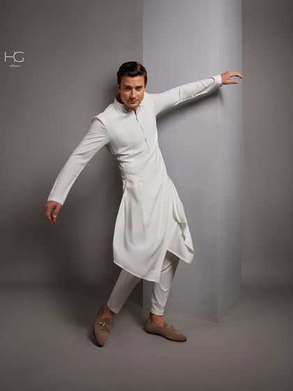 Glide into refinement with every step. This all-white ensemble features an asymmetrical, draped kurta that creates a dynamic and artistic silhouette.