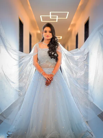 A creative shot using the gown's cape to create a dramatic, wing-like effect, adding a high-fashion feel.