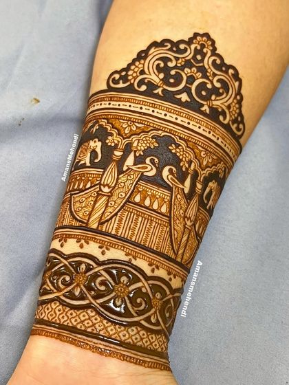 A detailed arm band featuring a procession of peacocks and elephants within a palace setting. The intricate architecture and graceful birds create a royal look.