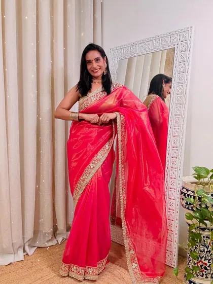 This bright pink organza saree with a Gota Patti border is a stunning choice for a wedding or festive event. It's vibrant, lightweight, and looks very celebratory.