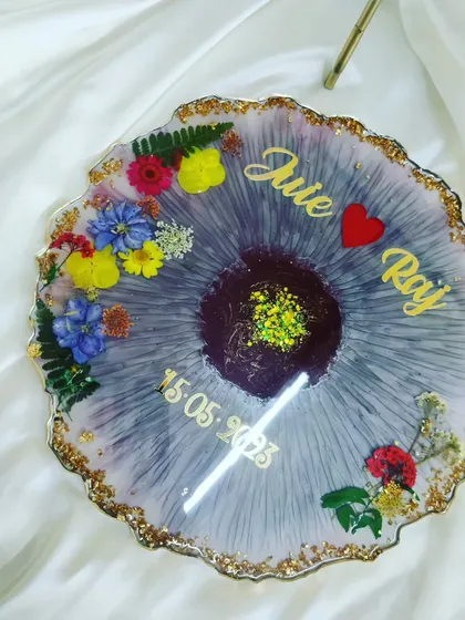 A beautiful customized resin table decor piece for the newlywed couple, Juie and Raj, featuring their names and wedding date.