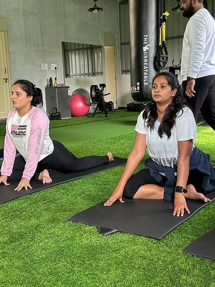 Our members finding their focus during a yoga session. The green turf provides a comfortable and calming environment for floor exercises and mind-body connection.