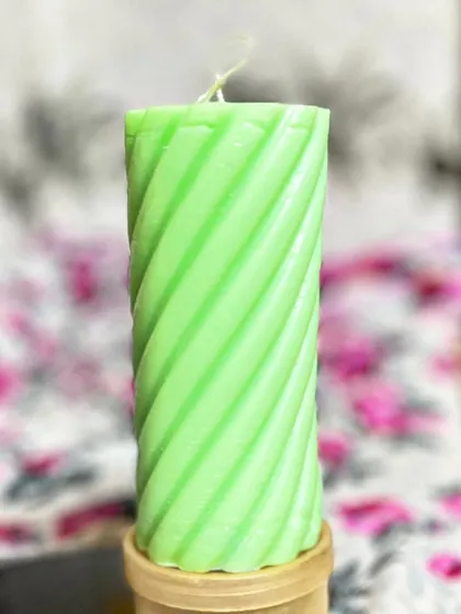 A close-up of the clean, sharp lines on a lime green spiral pillar candle. These are perfect for parties, weddings, or as part of a gift hamper.