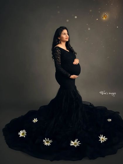 A whimsical touch to a classic black gown portrait. The mother-to-be looks up at a glowing honeybee, symbolizing new life and the sweetness of motherhood.