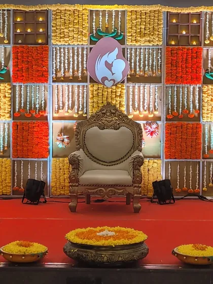 A wider view of the marigold panel backdrop, showing the full stage with the ornate throne and floor lighting. This setup is perfect for traditional ceremonies and photographs.