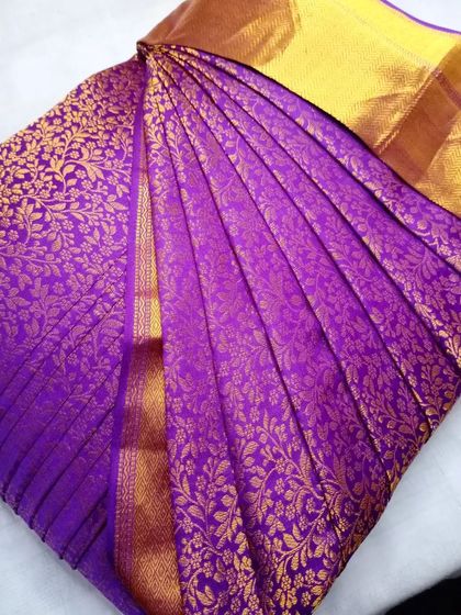 This vibrant purple Kanjeevaram is a feast for the eyes. The pleats are set to showcase its rich texture and golden motifs.