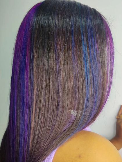 A beautiful blend of purple and blue highlights on straight, dark hair. This look shows how you can add a pop of creative color for a fun and unique style.