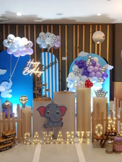 A complete look at the adorable elephant-themed setup for Samanvi's first birthday, with a custom name sign and "ONE" block.