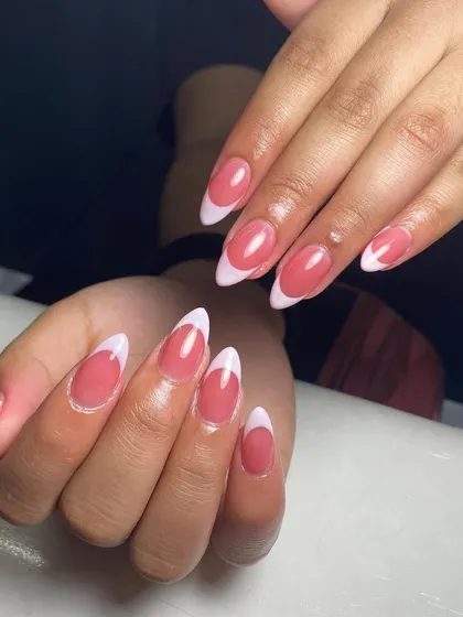 A beautiful example of a classic French manicure on almond-shaped nails, showing off the clean lines and glossy finish.