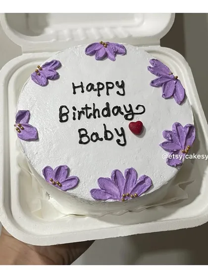 A floral-themed birthday bento cake with purple flowers and a simple 'Happy Birthday Baby' message.