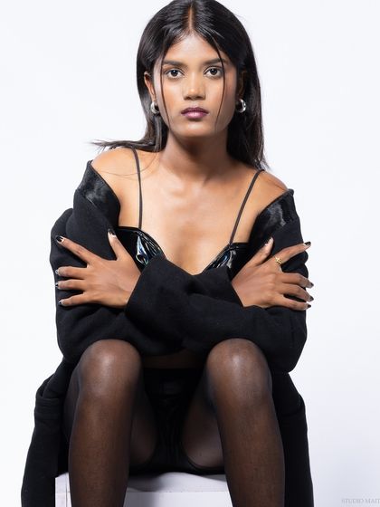 A close-up of the model in the black vinyl top, with a direct and engaging expression.