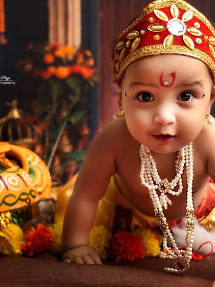 A close-up shot of a baby boy dressed as Krishna, crawling towards the camera. His direct gaze and sweet expression are simply heart-melting.
