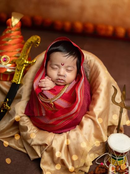 A close-up portrait within the Jijabai setup, showcasing the intricate details of the nose ring and bindi on the baby's peaceful face.