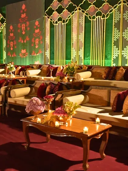 A luxurious lounge area with plush seating and intricate decor. The warm lighting and rich colours create an inviting space for guests to relax and enjoy the festivities.