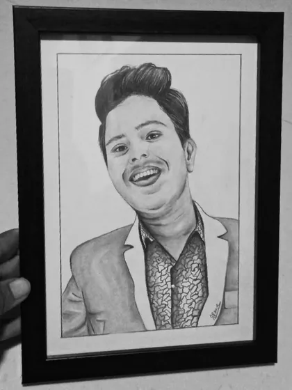 A framed A5 pencil sketch being held up for display. This shows how a smaller, affordable sketch can become a meaningful and high-quality gift.