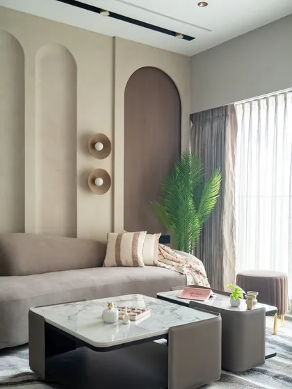 This living space is an ode to tactile minimalism and sculptural calm. The muted earthy tones create an inviting atmosphere, while the architectural arched niches add visual depth and a quiet rhythm to the room.