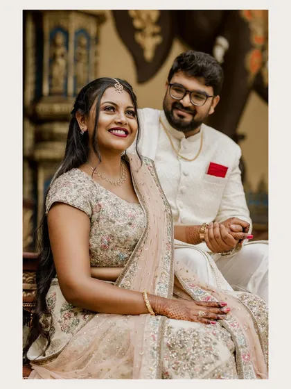 Yashu and Kushal share a happy moment during their engagement, seated in a regal, traditional setting.