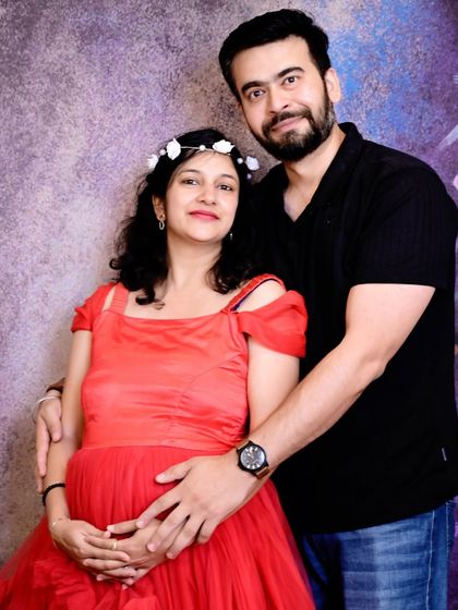 A classic couple's maternity portrait. The vibrant red gown stands out beautifully, and their pose shows their partnership on this incredible journey.