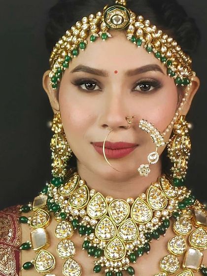 A beautiful bride wearing a Kundan set with large, leaf-shaped stones and green bead drops. A lovely and unique choice.