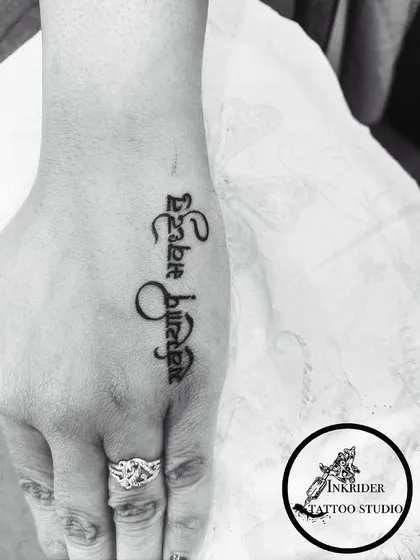 A beautiful script tattoo on the hand, showing our skill in creating elegant calligraphy for a highly visible placement.