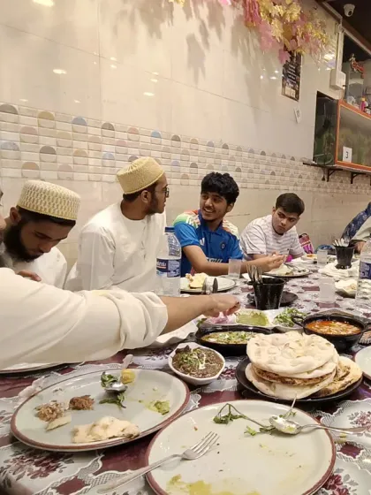 While I love the traditional Dastarkhwan setup, I also offer comfortable table and chair arrangements. Here, a family is enjoying their meal together, showing the flexibility of our space to suit your preference for any gathering.