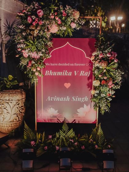 "We have decided on forever." The welcome sign for Bhumika and Avinash, framed by a lavish arrangement of pink and white flowers. It's a bold and romantic statement to greet their guests.