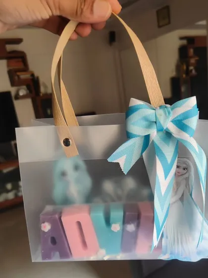 Holding up the personalized "Frozen" gift bag, showing how it's ready to be gifted.
