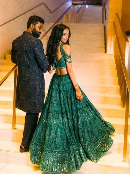 A stunning "over the shoulder" moment. Nisha's emerald green Falguni Shane Peacock lehenga for the Sangeet was all about movement and sparkle, perfectly complemented by Vishal's custom-embroidered dark sherwani.