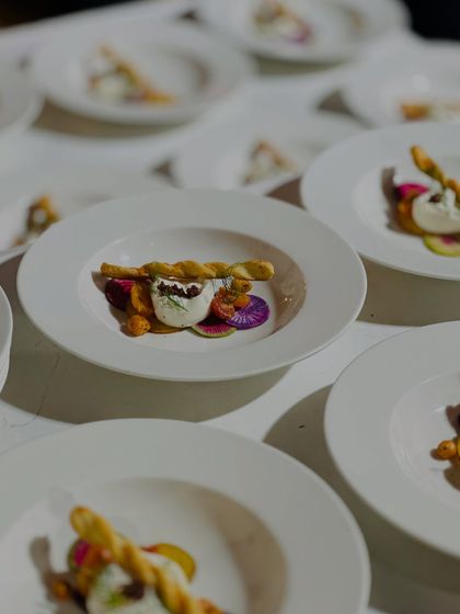 A row of elegantly plated starters ready for service at a large event. We ensure consistency and quality, whether we are catering for twenty people or two hundred.