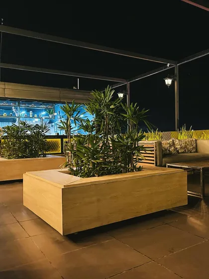 Large, movable planters are used here to create flexible zones within the open rooftop space. This allows the layout to be reconfigured for different events while consistently maintaining the presence of greenery.